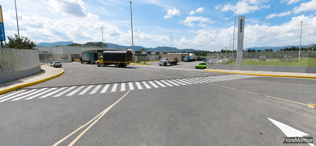 Acceso a planta de Corona con camiones, industria manufacturera colombiana
